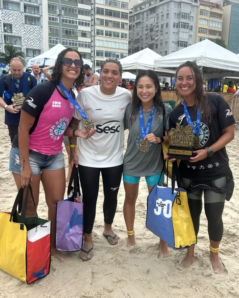 Carol e suas companheiras celebram o revezamento no Rei e Rainha do Mar.