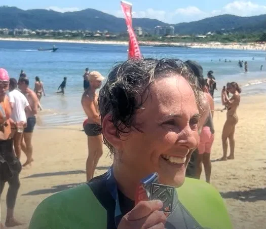 Fabiane com a medalha na chegada, no cartão de resultados da Navegantes.