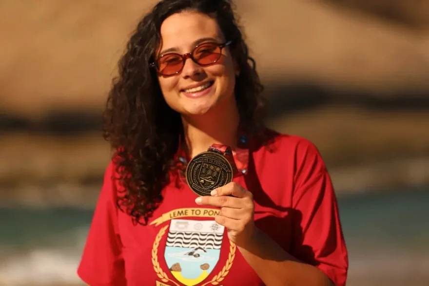 Júlia celebra a chegada com sua medalha.