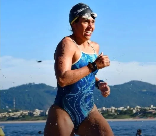Marcella saindo da água, no cartão de resultados da Navegantes.