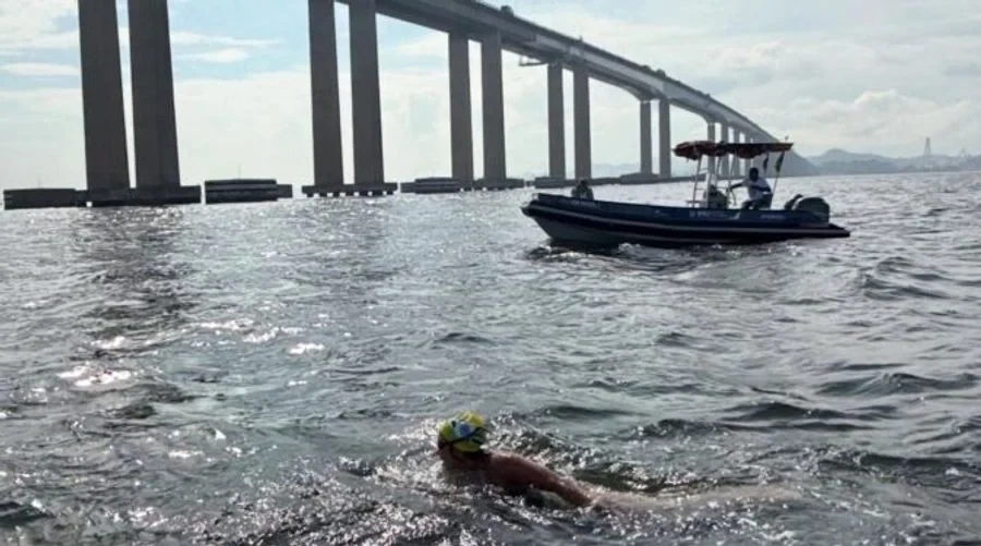 Patrícia nadando na Baía de Guanabara, com barco de apoio.