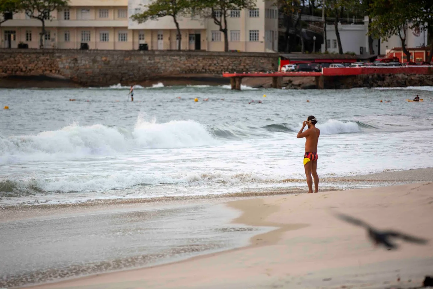 Nadador observa a arrebentação antes de entrar no mar.